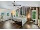 Spacious bedroom with wood floors, decorative wall art, lots of natural light, and a ceiling fan at 10545 Mount Holly Huntersville Rd, Huntersville, NC 28078