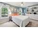 Airy bedroom with blue accent wall, large windows, and built-in shelving at 10545 Mount Holly Huntersville Rd, Huntersville, NC 28078