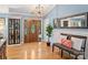 Inviting foyer with a wood door, hardwood floors, decorative lighting and a stylish bench at 10545 Mount Holly Huntersville Rd, Huntersville, NC 28078