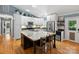 Bright eat-in kitchen featuring white cabinetry, stainless appliances, and a spacious island with granite countertop and bar seating at 10545 Mount Holly Huntersville Rd, Huntersville, NC 28078