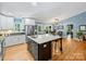 Bright kitchen featuring white cabinetry, stainless appliances, and a spacious island with granite countertop and bar seating at 10545 Mount Holly Huntersville Rd, Huntersville, NC 28078