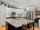 Eat-in kitchen featuring white cabinetry, stainless appliances, and a spacious island with granite countertop and bar seating at 10545 Mount Holly Huntersville Rd, Huntersville, NC 28078