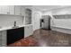 Kitchenette features white and gray cabinets, sleek black hardware, a black sink, and stainless fridge at 10545 Mount Holly Huntersville Rd, Huntersville, NC 28078