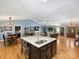 Bright living room featuring a kitchen island, spacious seating, vaulted ceilings, and hardwood flooring throughout at 10545 Mount Holly Huntersville Rd, Huntersville, NC 28078