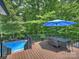 Outdoor dining area with a dark table and chairs and a view of the trees and the pool at 10545 Mount Holly Huntersville Rd, Huntersville, NC 28078