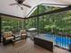 Relaxing screened porch with a ceiling fan, wicker furniture, and a view of the pool and trees at 10545 Mount Holly Huntersville Rd, Huntersville, NC 28078