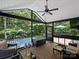 Screened porch featuring a ceiling fan, wicker furniture, and a view of the pool and trees at 10545 Mount Holly Huntersville Rd, Huntersville, NC 28078