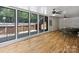 Bright sun room with wood flooring and a view of the backyard deck and stairs at 10545 Mount Holly Huntersville Rd, Huntersville, NC 28078