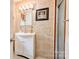 Bright bathroom features a white vanity, decorative mirror, and a tiled shower with glass door at 109 Ashley St, Shelby, NC 28150