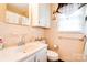 Full bathroom with decorative mirror, window, and neutral-toned tile walls at 109 Ashley St, Shelby, NC 28150