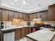 View of the kitchen with wooden cabinets, tile countertops, and modern appliances at 11121 Sevilla Ct, Charlotte, NC 28226