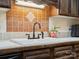 Close-up of the kitchen sink with tile countertops and wooden cabinets at 11121 Sevilla Ct, Charlotte, NC 28226