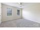 Neutral bedroom featuring plush carpet, ceiling fan, and two bright windows at 112 Brookshire Dr, Fort Mill, SC 29715