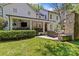 Expansive backyard with covered patio, outdoor kitchen, fireplace, seating area, and lush landscaping at 1200 Rutledge Ave, Charlotte, NC 28211