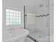 Bathroom boasts a soaking tub, seamless glass shower, white tile, and hexagon tile flooring at 1200 Rutledge Ave, Charlotte, NC 28211
