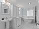 Elegant bathroom featuring white cabinets, marble countertops, a pedestal sink, and freestanding tub at 1200 Rutledge Ave, Charlotte, NC 28211
