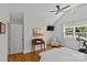 Bright bedroom with hardwood floors, ceiling fan, desk, chair, and large window at 1200 Rutledge Ave, Charlotte, NC 28211