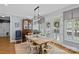 Elegant dining room featuring a rustic table, modern chandelier, and doors leading to the outdoor area at 1200 Rutledge Ave, Charlotte, NC 28211