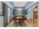 Elegant dining room with blue walls, wainscoting, hardwood floors, and a stunning chandelier at 1200 Rutledge Ave, Charlotte, NC 28211