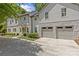 Two-story home featuring a large concrete driveway, gray siding, stone accents, and an attached two-car garage at 1200 Rutledge Ave, Charlotte, NC 28211