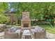 Outdoor stone fireplace with seating area, perfect for cozy gatherings in the landscaped backyard at 1200 Rutledge Ave, Charlotte, NC 28211
