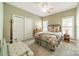 A cozy bedroom featuring a window with shutters, bedside table and decor, with carpeted floors at 12039 Lawings Corner Dr, Huntersville, NC 28078