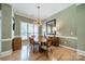 Elegant dining room featuring a modern chandelier, neutral paint, and beautiful hardwood floors at 12039 Lawings Corner Dr, Huntersville, NC 28078