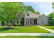 Charming brick home boasts lush lawn, mature trees, and inviting front porch perfect for relaxing at 12039 Lawings Corner Dr, Huntersville, NC 28078