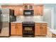 Close up view of kitchen featuring wooden cabinets, black appliances, and bright white countertops at 12039 Lawings Corner Dr, Huntersville, NC 28078
