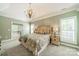 Spacious main bedroom featuring neutral paint, tray ceiling, a chandelier, and an ensuite bathroom at 12039 Lawings Corner Dr, Huntersville, NC 28078