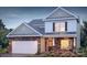 Charming two-story home featuring a stone facade, white siding, and an attached garage with landscaped yard at 136 Parker Claire Ln, Kings Mountain, NC 28086