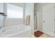 Bright bathroom featuring soaking tub, shower, window, and neutral-colored walls at 16337 Greybriar Forest Ln, Charlotte, NC 28278