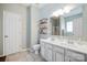 Bright bathroom with double vanity, decorative mirror, and open shelving for storage at 16337 Greybriar Forest Ln, Charlotte, NC 28278