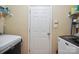 Functional laundry room featuring a washer, dryer, door, and storage shelves at 16337 Greybriar Forest Ln, Charlotte, NC 28278