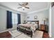 Inviting bedroom featuring hardwood floors, ceiling fan, large window, and a queen bed at 16337 Greybriar Forest Ln, Charlotte, NC 28278