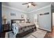 Inviting bedroom featuring hardwood floors, ceiling fan, large window, and a queen bed at 16337 Greybriar Forest Ln, Charlotte, NC 28278