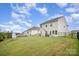 A sprawling backyard showing the house's exterior, featuring a well-maintained lawn and privacy fence at 18026 Stark Way, Charlotte, NC 28278