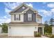 Charming two-story home with a two-car garage and stone accents, set against a beautiful blue sky at 18026 Stark Way, Charlotte, NC 28278