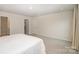 Neutral main bedroom features soft carpet, closet and ensuite bathroom entrances at 18026 Stark Way, Charlotte, NC 28278