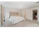 Spacious main bedroom features a tufted headboard, ensuite bathroom, and walk-in closet at 18026 Stark Way, Charlotte, NC 28278