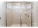 Tiled shower with glass door enclosure and transom window for natural light at 18026 Stark Way, Charlotte, NC 28278