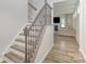 Elegant staircase with hardwood treads and decorative iron railing leads to a naturally lit living area at 18026 Stark Way, Charlotte, NC 28278