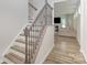 Elegant staircase with hardwood treads and decorative iron railing leads to a naturally lit living area at 18026 Stark Way, Charlotte, NC 28278