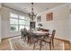Bright dining room boasts large windows and detailed chandelier with an elegant table set on a decorative rug at 18311 Rosapenny Rd, Charlotte, NC 28278
