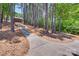 Long driveway leading to a home nestled among tall trees, offering privacy and a natural setting at 18311 Rosapenny Rd, Charlotte, NC 28278