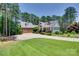A charming two-story home with a manicured lawn, lush landscaping, and a spacious driveway leading to a two-car garage at 18311 Rosapenny Rd, Charlotte, NC 28278