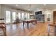 Bright game room features stone fireplace, pool table and hardwood floors at 18311 Rosapenny Rd, Charlotte, NC 28278