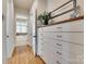 Hallway with white dresser, dark hardware, hardwood floors, and decor at 18311 Rosapenny Rd, Charlotte, NC 28278