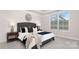 Modern bedroom featuring a padded headboard, bedside tables with lamps, and large window at 2043 Skyhawk Dr, York, SC 29745