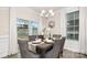 Elegant dining room with a table set for four, white curtains, stylish chandelier, and sliding glass doors at 2043 Skyhawk Dr, York, SC 29745